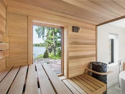 The inside of a sauna looking out a window to the outdoors from inside a bathroom.